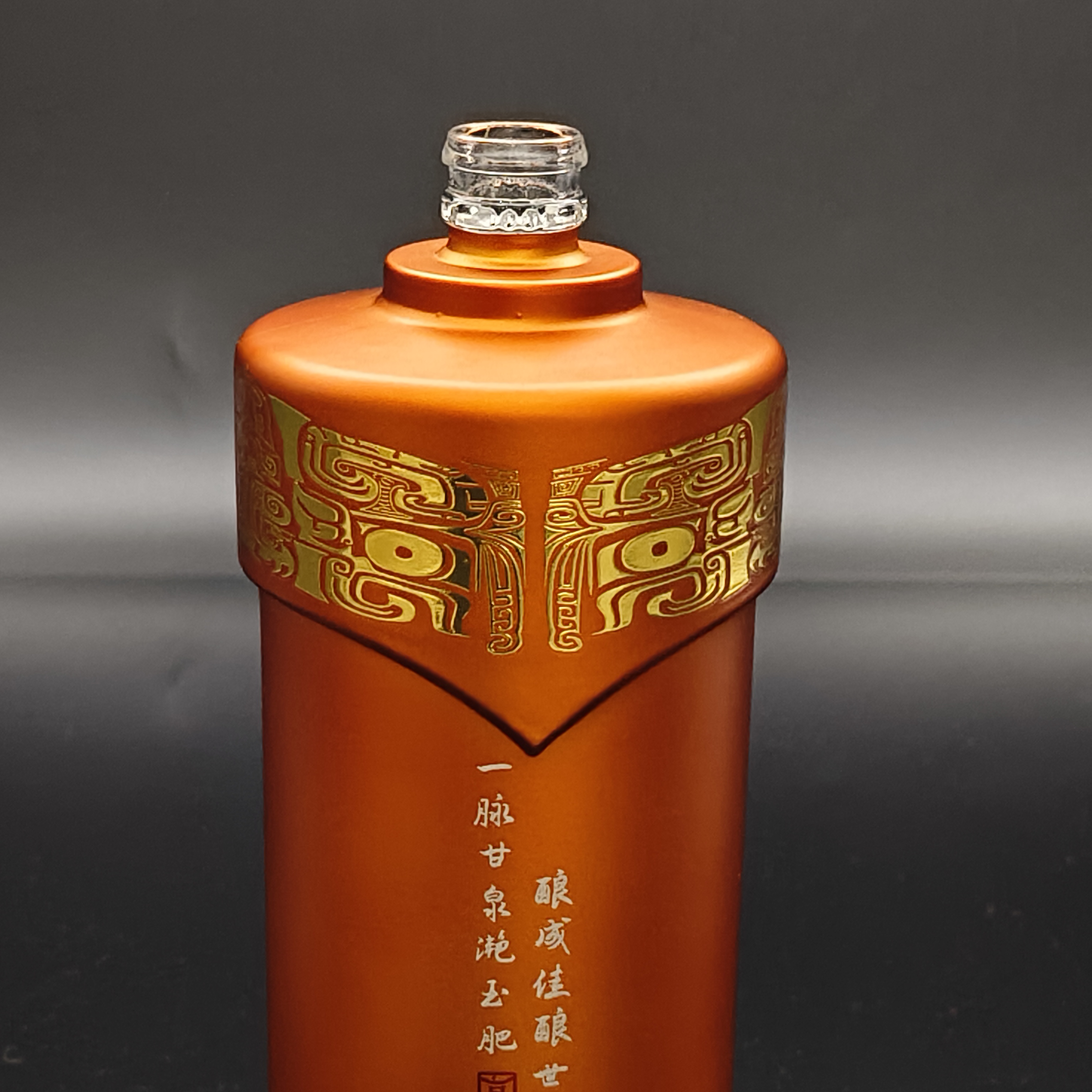 Detail of high-end low-temperature relief gold decal on a matte spirits bottle, showcasing intricate embossed metallic patterns.